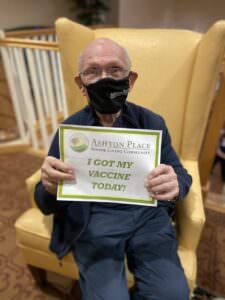 An Ashton Place resident holds a sign saying "I got my vaccine today!"