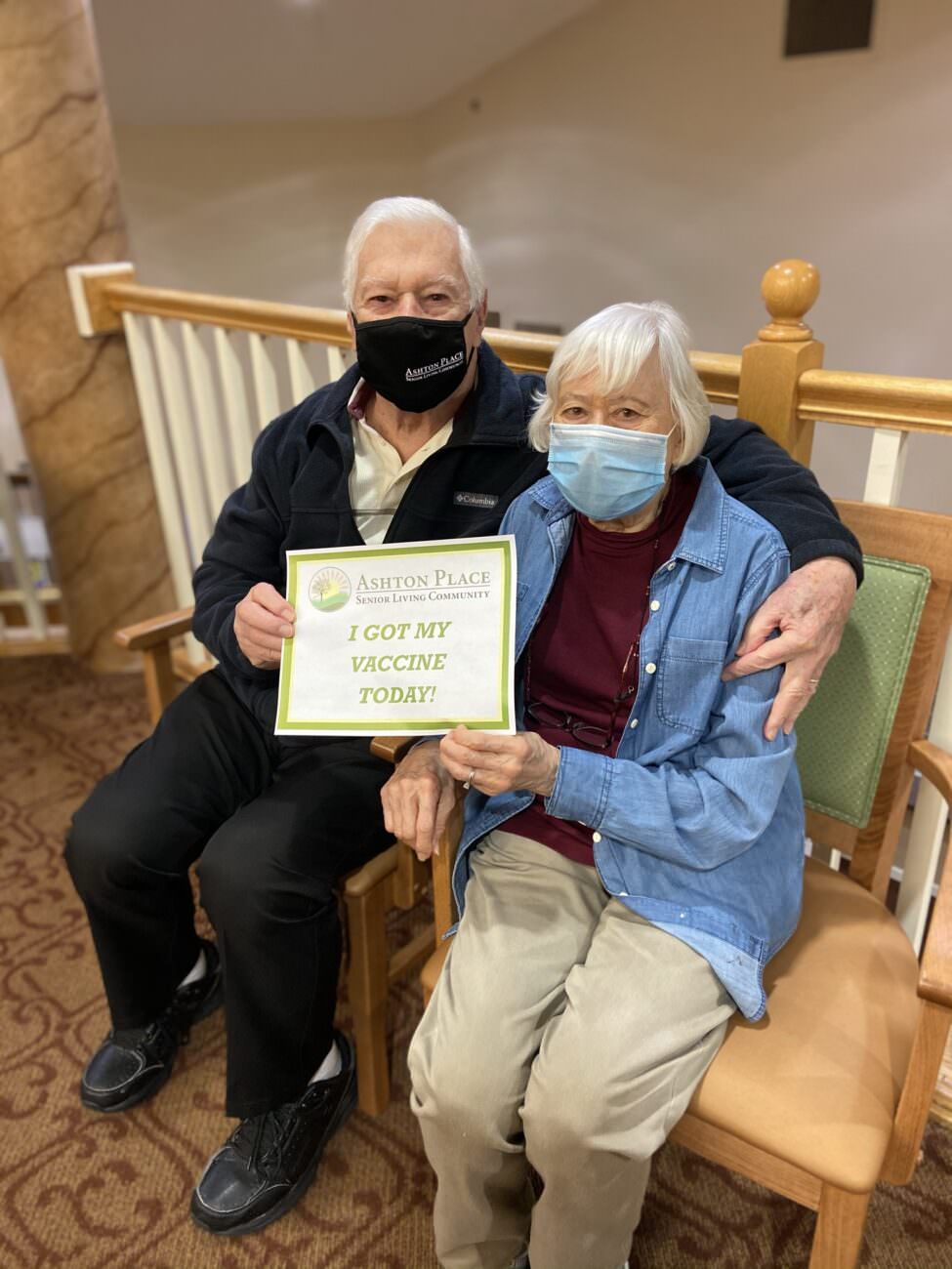 Two Ashton Place residents hold a sign saying "I got my vaccine today!"